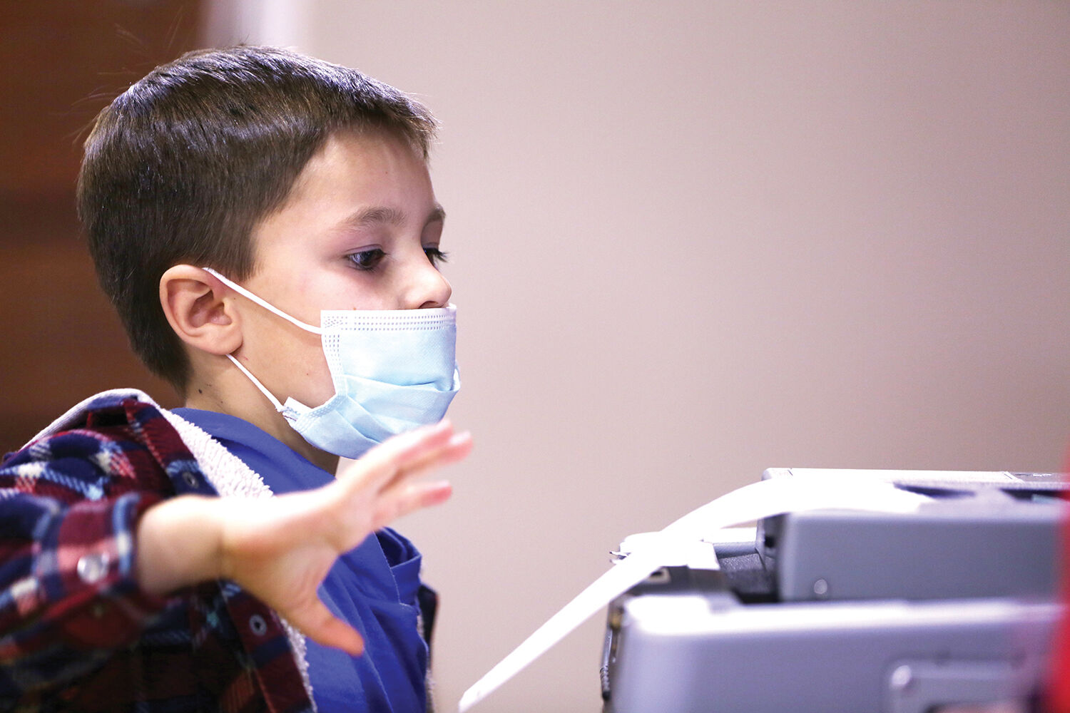 Trigg Taylor, 6, helps feed his mom’s ballot through the machine
